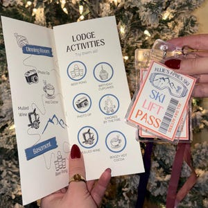 Puede incluir: Un folleto con actividades de lodge y un pase de esquí. El folleto presenta ilustraciones de actividades como beer pong, sesiones de fotos y chocolate caliente. El pase de esquí está en un soporte transparente y tiene el texto "SKI LIFT PASS".