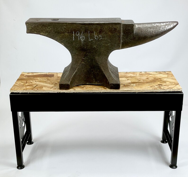 Pode incluir: Uma bigorna grande e resistente com uma base de metal preto e uma parte superior de madeira. A bigorna &eacute; feita de ferro e tem uma parte superior arredondada. A bigorna est&aacute; etiquetada com "196 Lbs".