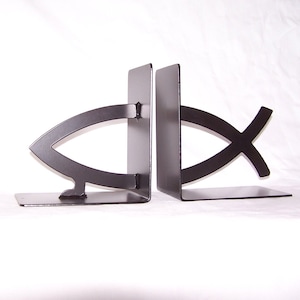 May include: A pair of black metal bookends shaped like the Christian ichthys symbol, also known as the Jesus fish.