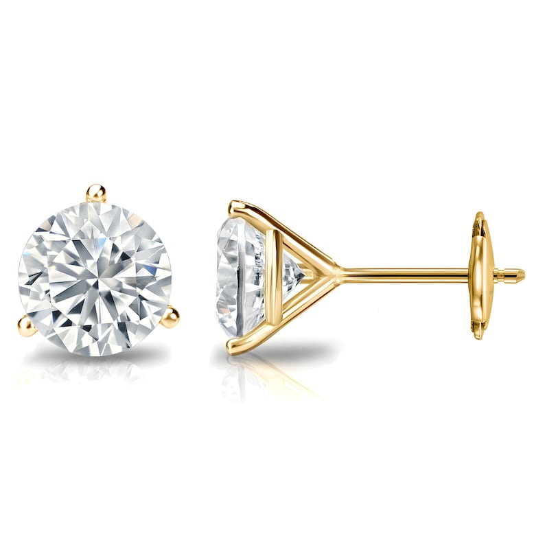 May include: A pair of gold stud earrings with large, round, clear gemstones. The earrings are set in a classic three-prong setting, showcasing the brilliance of the stones. The posts and backs are also gold, creating a cohesive and elegant look.