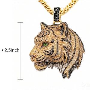 May include: Gold-toned tiger pendant necklace with black and clear crystal accents. The tiger head is approximately 2.5 inches in length. The necklace features a gold chain.
