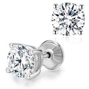 May include: A pair of sparkling diamond stud earrings. Each earring features a round, brilliant-cut diamond set in a four-prong, silver-colored setting. The diamonds reflect light, creating a brilliant display against a white background.