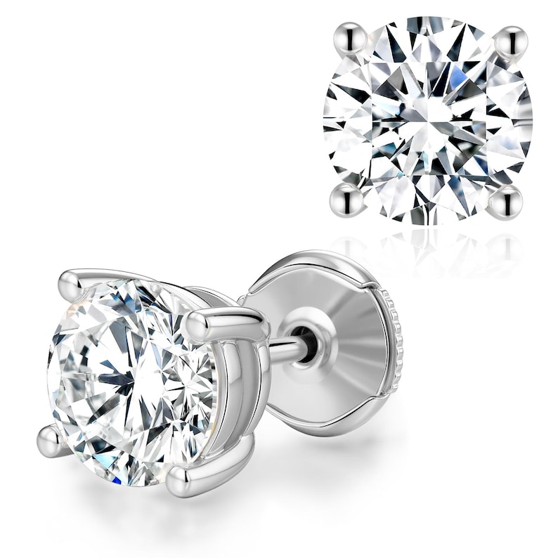 May include: A pair of sparkling diamond stud earrings. Each earring features a round, brilliant-cut diamond set in a four-prong, silver-colored setting. The diamonds reflect light, creating a brilliant display against a white background.