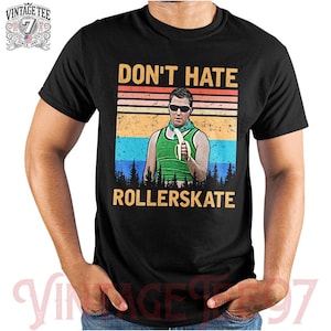 Może przedstawiać: Czarny T-shirt z grafiką w stylu vintage przedstawiającą mężczyznę trzymającego banana i napis "Don't Hate Rollerskate".
