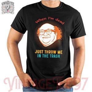 May include: Black t-shirt featuring a cartoon image of a man with red hair and glasses. The text "When I'm dead Just Throw Me In The Trash" is printed on the shirt.