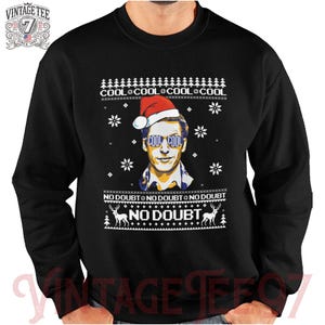 May include: Black Christmas sweater with a white snowflake pattern. The sweater features a cartoon image of a man wearing a Santa hat and sunglasses with the text "Cool Cool Cool Cool No Doubt" printed on the sweater.