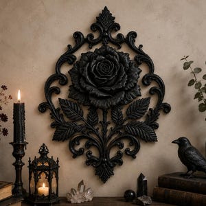May include: A black wall-mounted decorative plaque featuring a central rose bloom surrounded by intricate scrollwork and foliage. The piece is symmetrical with a pointed top and bottom, showcasing detailed petal textures and ornate carved patterns.