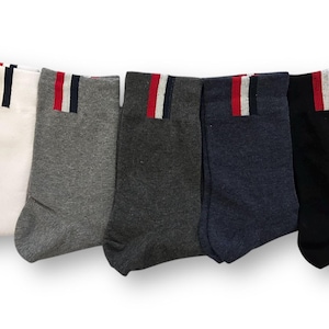 Könnte beinhalten: Fünf Paar Socken mit einem roten, weißen und blauen Streifen oben. Die Socken sind in Weiß, Grau, Dunkelgrau, Marineblau und Schwarz.