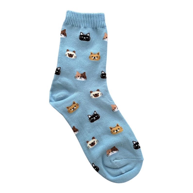 Puede incluir: Un calcet&iacute;n azul claro con un patr&oacute;n repetido de caras de gato en negro, marr&oacute;n y naranja. El calcet&iacute;n est&aacute; hecho de un material suave y est&aacute; dise&ntilde;ado para adaptarse al pie. Un accesorio divertido y juguet&oacute;n.