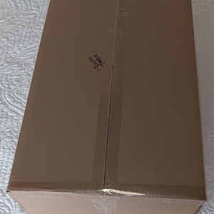 May include: A brown cardboard box with the text "123456 78910" written on it.