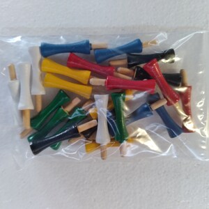 May include: A plastic bag filled with colorful wooden dowels. The dowels are in various colors, including red, blue, yellow, green, and white. The dowels are all the same size and shape, and they are arranged in a random order.