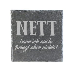 Könnte beinhalten: Ein quadratischer Untersetzer aus dunkelgrauem Schiefer mit rauer, strukturierter Kante. Die Oberfläche zeigt den eingravierten weißen Schriftzug "NETT" in einer großen Serifenschrift, gefolgt von dem kleineren kursiven Text "kann ich auch. Bringt aber nichts!" mittig.