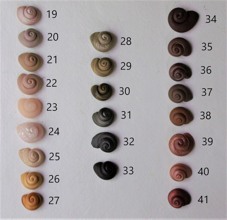 Peut inclure: Une collection de 22 petites coquillages peints &agrave; la main dans diff&eacute;rentes couleurs et motifs, num&eacute;rot&eacute;s de 19 &agrave; 41.