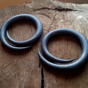 Peut inclure: Deux jauges d'oreille en bois spiral&eacute;es grises. Les jauges sont en bois et ont une finition lisse et polie.