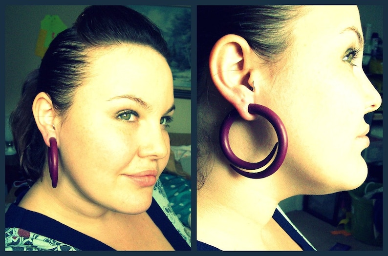 Peut inclure: Une femme aux cheveux fonc&eacute;s porte de grandes boucles d'oreilles en bois de couleur violette. Les boucles d'oreilles mesurent environ 5 cm de diam&egrave;tre.