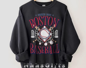 May include: Black sweatshirt with a baseball-themed graphic. The design includes the text "BOSTON BASEBALL" in red and blue, a baseball, crossed bats, and the text "SINCE 1901". The sweatshirt has rolled-up sleeves.