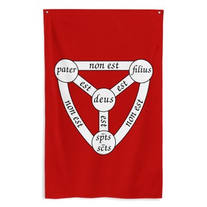 May include: A red wall hanging featuring a white diagram with Latin text. The diagram includes three circles connected by lines, with the words "pater," "filius," "deus," and "spts scts" inside the circles. The text "non est" and "est" are also present.
