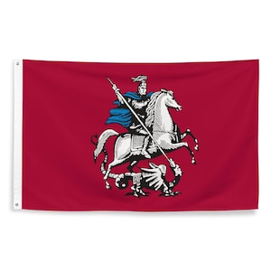 May include: A red flag with a white image of a knight on horseback slaying a dragon. The knight is wearing blue armor and a blue cape. The dragon is black.