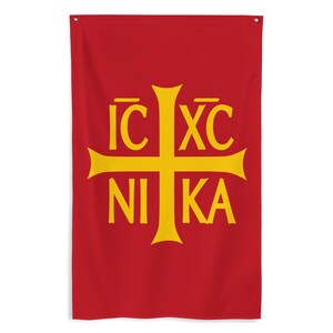 May include: A red wall flag with a yellow cross and the Greek words IC XC NIKA. The flag has a simple design with a single grommet at the top for hanging. The text and cross are centered on the flag.