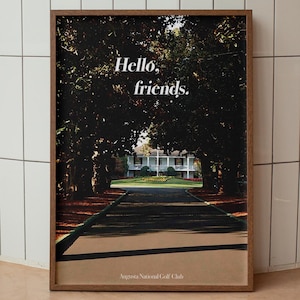 May include: A framed print of a golf course with a white building in the background. The print has the text "Hello, friends." and "Sea Island National Golf Club" at the bottom.