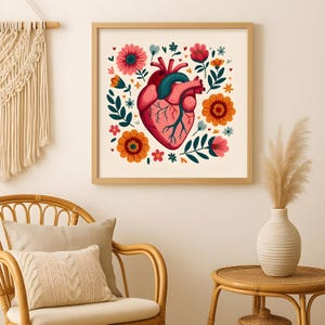 以下が含まれることがあります： カラフルな花と葉に囲まれた、人間の心臓の様式化されたイラストが描かれた額入りのプリント。心臓は赤とピンクの色合いで描かれ、青い静脈と動脈があります。花はオレンジ、ピンク、青の色合いです。
