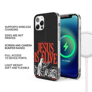 Op de afbeelding: Zwarte telefoonhoes met een witte en rode afbeelding met de tekst "JESUS IS ALIVE". De hoes is compatibel met draadloos opladen.