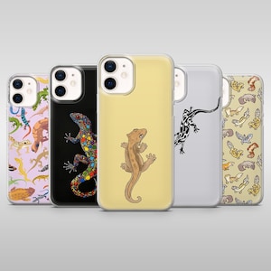 Könnte beinhalten: Eine Sammlung von Handyhüllen mit Eidechsen-Designs. Die Hüllen zeigen verschiedene farbenfrohe Eidechsen-Illustrationen auf weißem, schwarzem und gelbem Hintergrund. Die Hüllen bestehen aus einem transparenten, glänzenden Material.