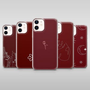 Może przedstawiać: Kolekcja pięciu bordowych etui na telefon z przezroczystymi krawędziami. Każde etui ma inny biały wzór linii, w tym kwiaty, różę, abstrakcyjną figurę i elementy niebieskie, takie jak księżyce i gwiazdy. Etui są przeznaczone do smartfona.