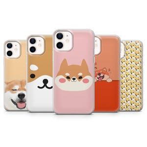 Puede incluir: Cinco fundas de teléfono diferentes con ilustraciones de perros Shiba Inu. Las fundas son transparentes, rosas, rojas y blancas con ilustraciones de perros Shiba Inu negros y marrones.