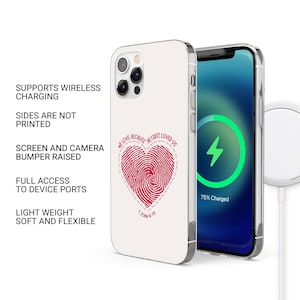 May include: A white phone case with a red heart design featuring a fingerprint and the text "We love because He first loved us. 1 John 4:19". The case is compatible with wireless charging.