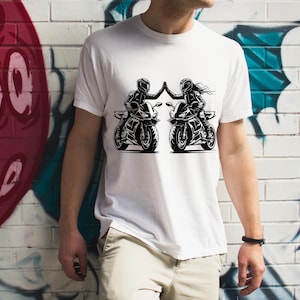 May include: White t-shirt with a black and white graphic of two people riding motorcycles. The graphic shows the riders giving each other a high five.