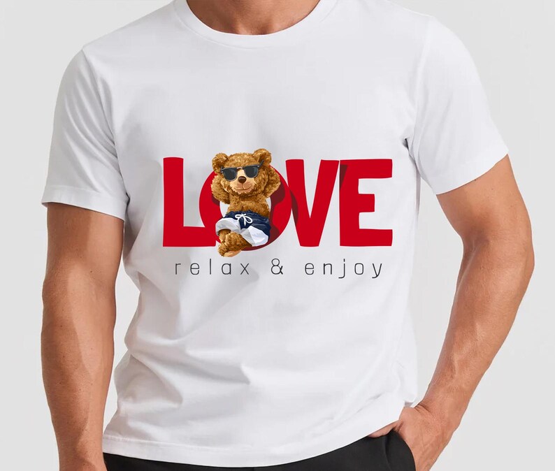 May include: White t-shirt featuring a red "LOVE" graphic and a cartoon bear wearing sunglasses, shorts, and trainers. The text "relax & enjoy" is printed below the word "LOVE".