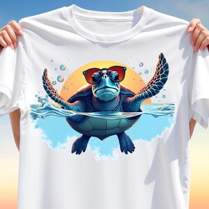 May include: White t-shirt featuring a cartoon turtle wearing sunglasses, emerging from water with outstretched flippers. The turtle is blue and green, set against a yellow sun and blue sky background. Bubbles float around the turtle.