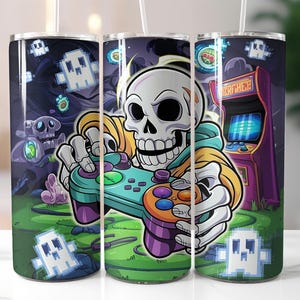 May include: A white tumbler with a colorful design featuring a skeleton holding a video game controller. The design also includes a retro arcade game with the text "Arcade" on the side.