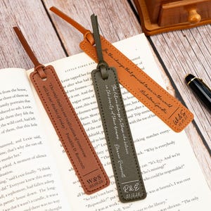 Può includere: Tre segnalibri in pelle marrone, verde oliva e arancione, ciascuno con un cinturino. I segnalibri hanno citazioni e iniziali incise. Un segnalibro recita: "Sii il cambiamento che vuoi vedere nel mondo."