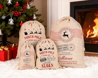 May include: Four beige drawstring burlap sacks of varying sizes featuring red and black printed graphics. Designs include silhouettes of Santa's sleigh with reindeer, North Pole Express Mail stamps, and text such as Do Not Open Before 25 December.