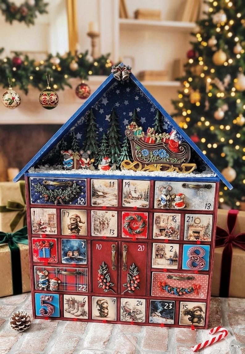 Puede incluir: Un calendario de adviento de madera con forma de casa y veinticuatro cajones numerados. El techo presenta una escena en miniatura con un trineo, Santa Claus y pinos. Cada caj&oacute;n muestra ilustraciones navide&ntilde;as, ratones, coronas y paisajes invernales, con tiradores de metal.
