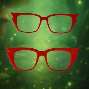 May include: Two pairs of red-framed eyeglasses with a unique, pointed design on the upper corners. The glasses are set against a blurred green background, creating a vibrant contrast. The frames have a rectangular shape.