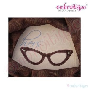 May include: Embroidered design of a pair of brown cat-eye glasses with the word "hers" in blue cursive above them.