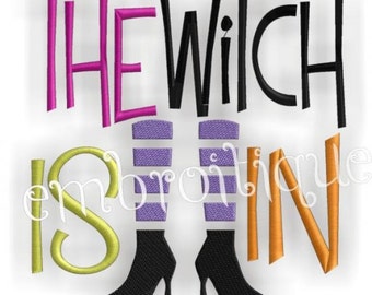 May include: Embroidered design featuring the text "The Witch is In" with a pair of black witch boots and purple striped stockings.