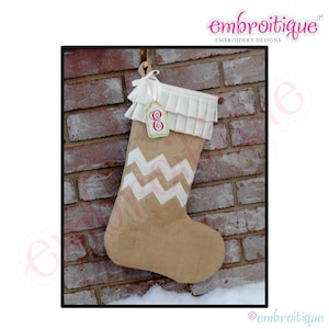 May include: A burlap Christmas stocking with a white chevron pattern and a white ruffled cuff. The stocking has a personalised tag with the letter "E" in red.
