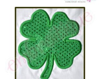 May include: A green four-leaf clover with a sparkly texture. The clover is outlined in a darker green.