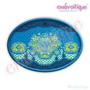 Pode incluir: Um desenho de bordado oval azul e branco com um padrão floral. O desenho apresenta um motivo central com flores e folhas amarelas e brancas, rodeado por uma borda de pontos azuis e brancos. O desenho é emoldurado por um oval azul.