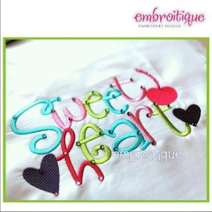 May include: Embroidered design on white fabric spelling "Sweet Heart" in teal, pink, green, and red thread. A red heart and a black heart are included in the design. The word "embroitiique" is in the top right corner.