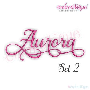 May include: Embroidered design of the name "Aurora" in a pink cursive font with a decorative flourish. The design is labeled "Set 2".