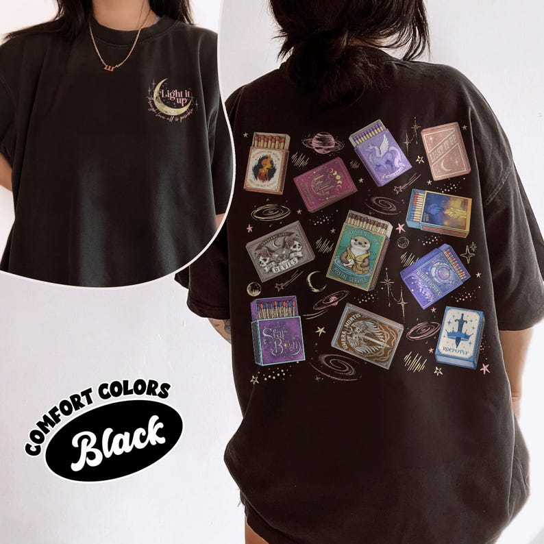 May include: Black Comfort Colors t-shirt with a graphic of matchboxes and celestial elements on the back. The front of the shirt has the text "Light it up" with a crescent moon design. The shirt is a relaxed fit.