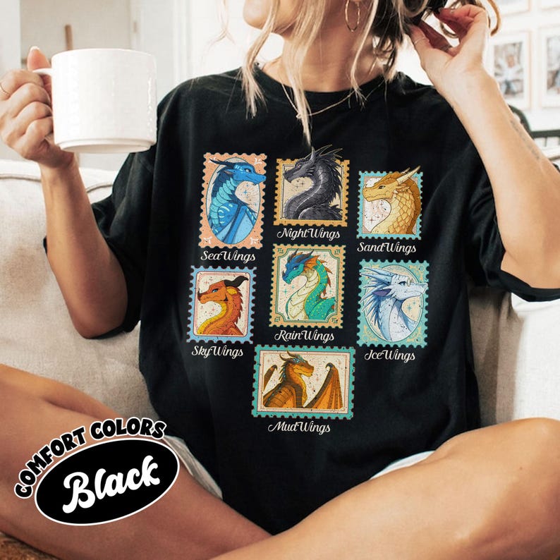 May include: Black t-shirt featuring colorful dragon illustrations in stamp-like designs. The shirt includes the text "SeaWings", "NightWings", "SandWings", "SkyWings", "RainWings", "IceWings", and "MudWings". The shirt also has the text "COMFORT COLORS Black".