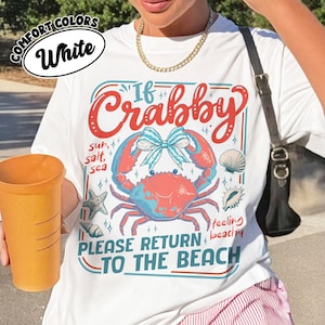 May include: White t-shirt with a crab graphic and the text "If Crabby, Please Return to the Beach." The design includes a crab, seashells, and starfish in red, blue, and white. The shirt is made of Comfort Colors material.