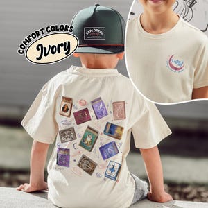 May include: Ivory-colored t-shirt with a graphic of matchboxes, a green and black hat with the text "EXPLORERS", and the text "COMFORT COLORS Ivory". The shirt also has a small graphic that says "Light it up".