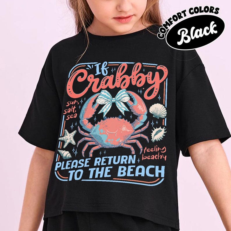 May include: Black t-shirt with a crab graphic and the text "If Crabby, Please Return to the Beach." The design includes a crab, seashells, and starfish in shades of pink, blue, and white. The words "Comfort Colors" and "Black" are also visible.